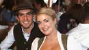 Kapten Bayern Munchen, Philipp Lahm bersama istrinya Claudia tersenyum saat menghadiri acara Oktoberfest di Munich, Jerman (2/9). (REUTERS/Alexander Hassenstein)