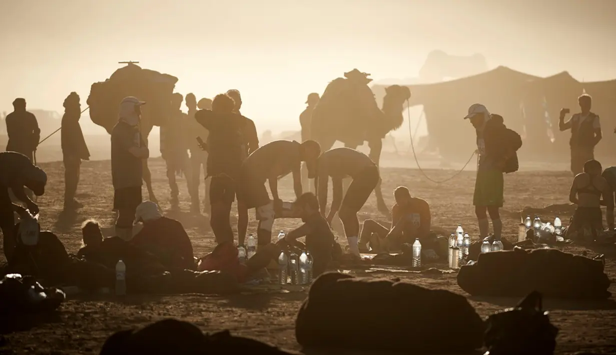 Para pelari bersiap sebelum memulai Etape 5 Marathon des Sables antara Hassi Tarfa dan Bou Makhlouf di selatan Gurun Sahara, Maroko, (15/4/2016). (AFP/Jean-Philippe Ksiazek)