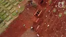 Foto udara menggambarkan lokasi pemakaman jenazah diduga terinfeksi Covid-19 (kanan) di TPU Pondok Ranggon, Jakarta, Kamis {30/4/2020). Berdasar data yang diumumkan pemerintah per 30 April 2020, 10.118 orang positif, 1.522 dinyatakan sembuh dan 792 meninggal. (Liputan6.com/Helmi Fithriansyah)