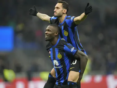 Gelandang Inter Milan Hakan Calhanoglu (atas) berselebrasi bersama Marcus Thuram setelah mencetak gol kedua timnya ke gawang Frosinone dalam duel pekan ke-12 Serie A 2023/2024 di Giuseppe Meazza, Senin (13/11/2023) dini hari WIB. (AP Photo/Luca Bruno)