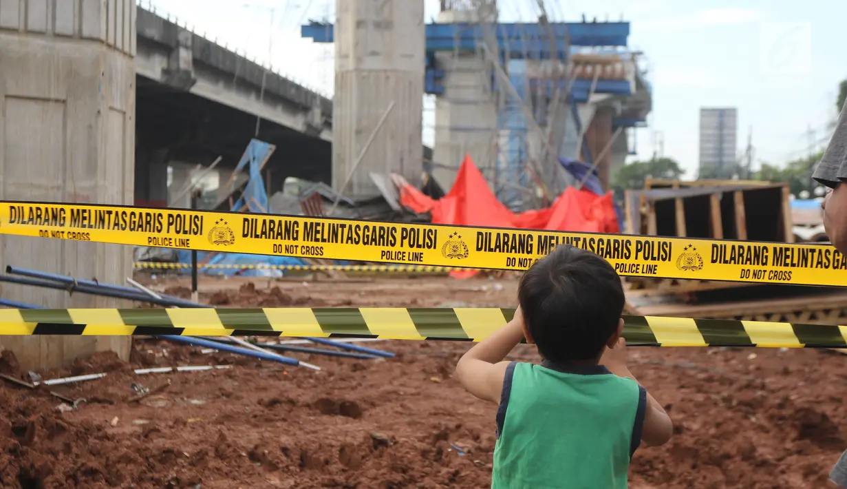 Seorang anak melihat kondisi tiang girder Tol Bekasi-Cawang-Kampung Melayu (Becakayu) yang ambruk di Kebon Nanas, Jakarta Timur, Selasa (20/2). Peristiwa terjadi saat para pekerja melakukan pengecoran pada penyangga tiang. (Liputan6.com/Arya Manggala)