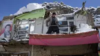 Seorang penduduk desa Afghanistan membersihkan salju setelah atap rumahnya rusak akibat longsoran salju, provinsi Panjshir, sebelah utara Kabul, Afghanistan (AP/Arsip).