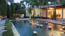 Penggunaan ornamen bola perak dan cahaya temaram membuat kolam renang terasa lebih romantis di malam hari.
