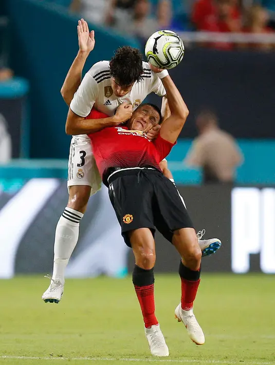 Bek Real Madrid Jesus Vallejo berebut bola dengan penyerang Manchester United Alexis Sanchez saat bertanding pada International Champions Cup di Miami Gardens, Fla (31/7). MU menang tipis 2-1 atas Madrid. (AP Photo / Brynn Anderson )