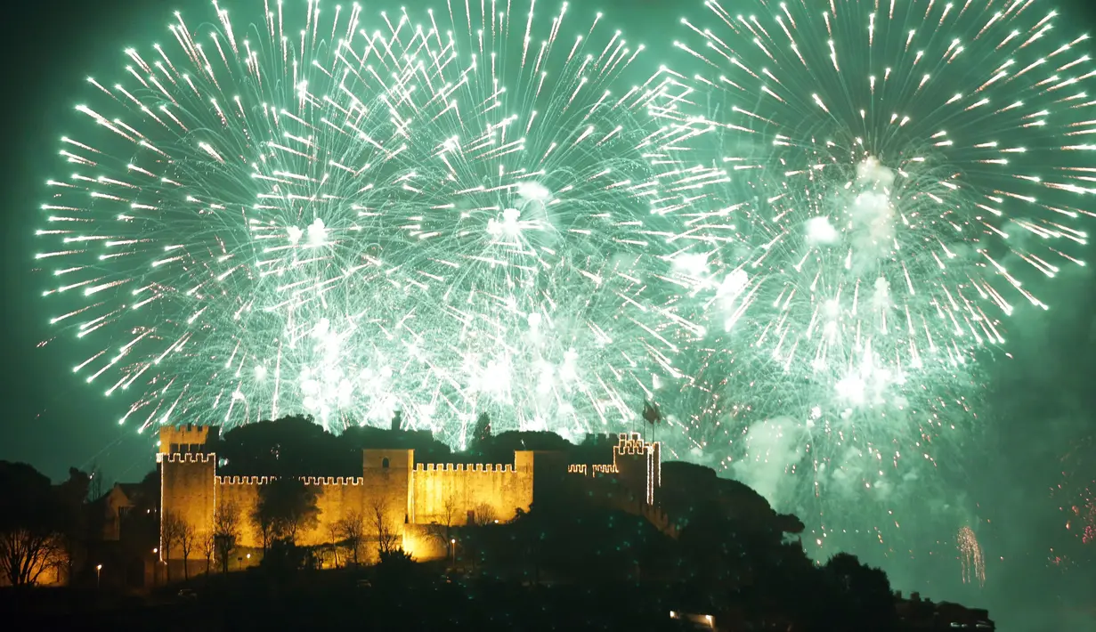 Kembang api menghiasi Kastil Saint George saat perayaan malam Tahun Baru 2019 di Lisbon, Portugal, Selasa (1/1). (AP Photo/Armando Franca)