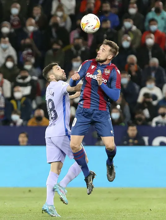 Pemain Barcelona Jordi Alba (kiri) berebut bola dengan pemain Levante Jorge Miramon (kanan) pada pertandingan sepak bola La Liga Spanyol di Stadion Ciutat de Valencia, Valencia, Spanyol, 10 April 2022. Barcelona menang 3-2. (AP Photo /Alberto Saiz)