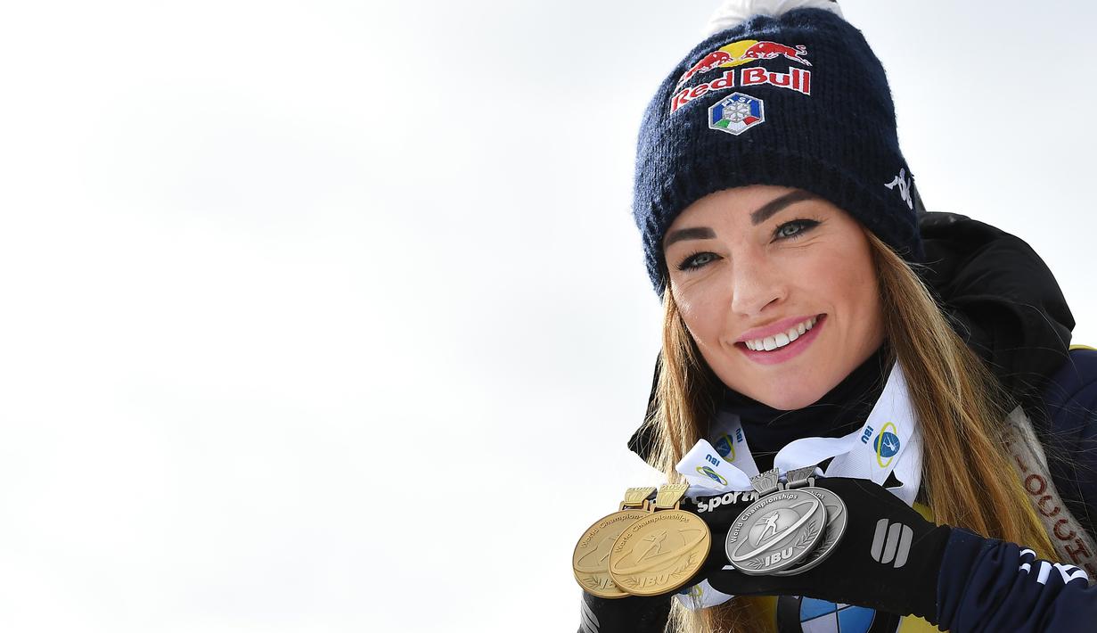 Atlet Biathlon asal Itali, Dorothea Wierer melihatkan medali usai mengikuti perlombaan Piala Dunia IBU Biathlon di Antholz-Anterselva, Itali, Minggu (23/2/2020). (Foto: AFP/Tiziana Fabi)