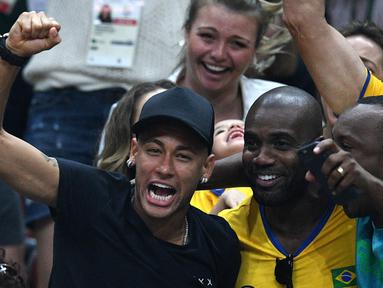 Aksi Neymar (kir)  saat mendukung timnas voli Brasil berlaga pada final bola voli Olimpiade Rio 2016 melawan Italia di Stadion Maracanazinho, Rio de Janeiro, (21/8/2016). (AFP/Johannes Eisele)