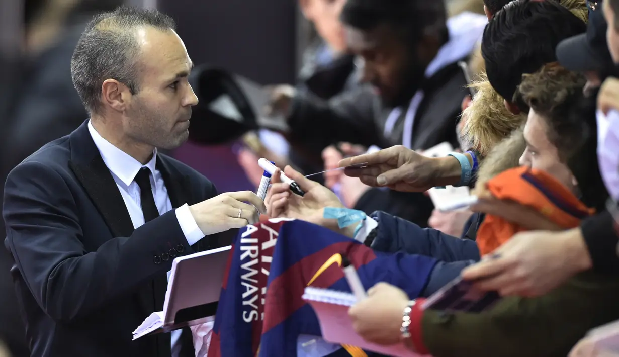 Gelandang Barcelona, Andres Iniesta, memberikan tanda tangan saat menghadiri malam penghargaan Ballon d'Or di Zurich, Senin (11/1/2016). Pada 2016 dirinya juga sempat menjadi tiga nominasi peraih Ballon d'Or. (AFP/Michael Buholzer)