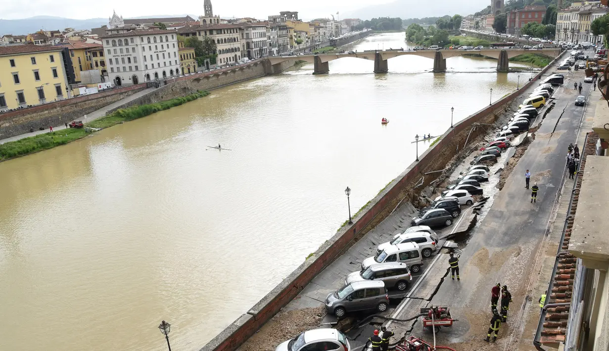 Puluhan mobil terpelosok saat parkir di pinggir sungai Arno yang tiba-tiba amblas di Lungarno Torrigiani, Florence, Italia (25/5). Menurut petugas, kejadian tersebut disebabkan oleh pecahnya pipa besar saluran air. (AFP PHOTO/CLAUDIO GIOVANNINI)