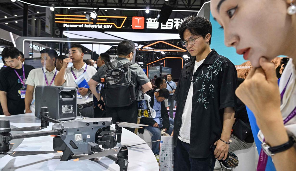 Pengunjung terlihat di stan DJI selama Drone World Congress (DWC) di Shenzhen pada 21 Mei 2026. (HECTOR RETAMAL/AFP)