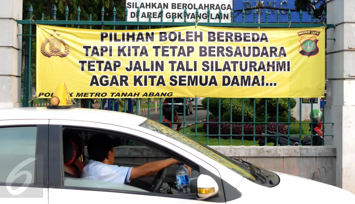 Spanduk himbauan jelang pelaksanaan Pilkada DKI putaran 2 terpampang di pintu masuk Kawasan GBK Jalan Gerbang Pemuda, Jakarta, Minggu (16/4). Pilkada DKI Jakarta putaran 2 akan berlangsung pada Rabu 19 April mendatang. (Liputan6.com/Helmi Fithriansyah)