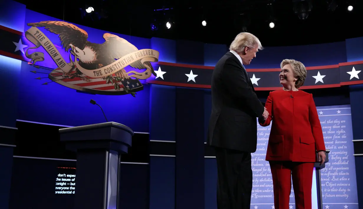 Calon presiden AS dari Partai Republik, Donald Trump dan rivalnya dari Partai Demokrat, Hillary Clinton saling berjabat tangan jelang dimulainya acara debat capres pertama di Hofstra University, New York, Senin (26/9). (REUTERS/Carlos Barria)