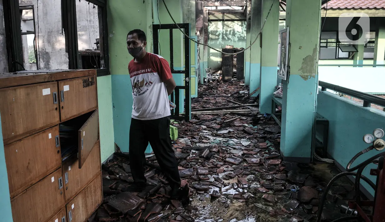 Seorang pria melihat kondisi salah satu ruangan yang terbakar di SMA Negeri 100 Jakarta, Rabu (1/7/2020). Kebakaran yang terjadi sekitar pukul 11.00 WIB tersebut diduga akibat korsleting listrik di salah satu ruangan lantai 2 sekolah. (merdeka.com/Iqbal S Nugroho)