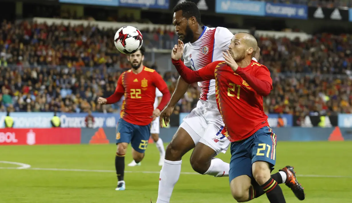 Gelandang Spanyol, David Silva, berebut bola dengan bek Kosta Rika, Kendall Waston, pada laga persahabatan di Stadion La Rosaleda, Sabtu (11/11/2017). Spanyol menang 5-0 atas Kosta Rika. (AP/Miguel Morenatti)