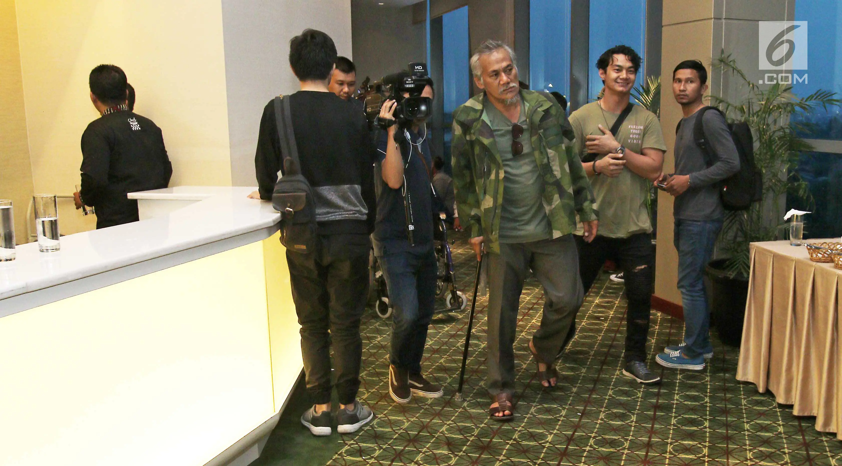 Aktor Tio Pakusadewo berjalan menggunakan tongkat usai mengalami kecelakaan, Jakarta, Rabu (11/10). Akibat kecelakaan tersebut, Tio Pakusadewo harus mendapatkan beberapa jahitan dan mengalami patah tulang. (Liputan6.com/Herman Zakharia)