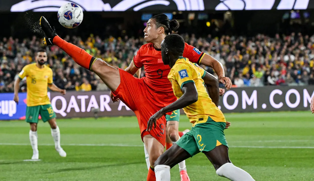 Pemain China, Zhang Yuning mengontrol bola dibayangi pemain Australia pada laga lanjutan Grup C Kualifikasi Piala Dunia 2026 yang berlangsung di Adelaide Oval, Adelaide, Australia, Kamis (10/10/2024). (AFP/Brenton Edwards)