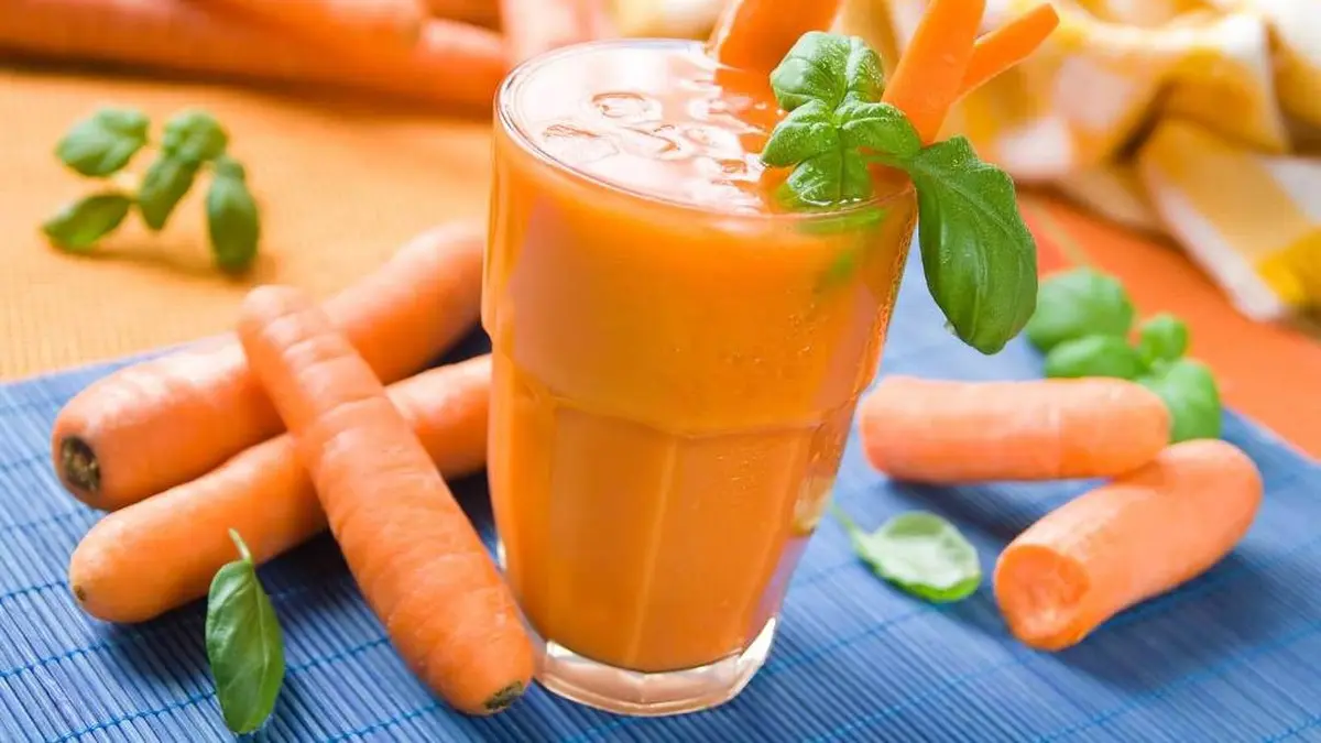 Segelas jus wortel segar dengan warna oranye cerah, kaya vitamin dan manfaat untuk kesehatan tubuh