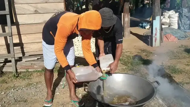 Karyawan Agustinus, memasak air aren menjadi gula merah.(Liputan6.com/Ahmad Akbar Fua)