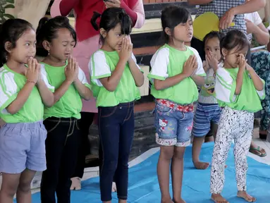 Anak-anak TK berdoa sebelum mengikuti sekolah di kamp pengungsian Gor Swace Pura, Klungkung, Bali, Kamis (28/09). Kegiatan tersebut bertujuan menghilangkan rasa trauma serta sebagai sarana bermain anak korban bencana alam. (Liputan6.com/Gempur M Surya)