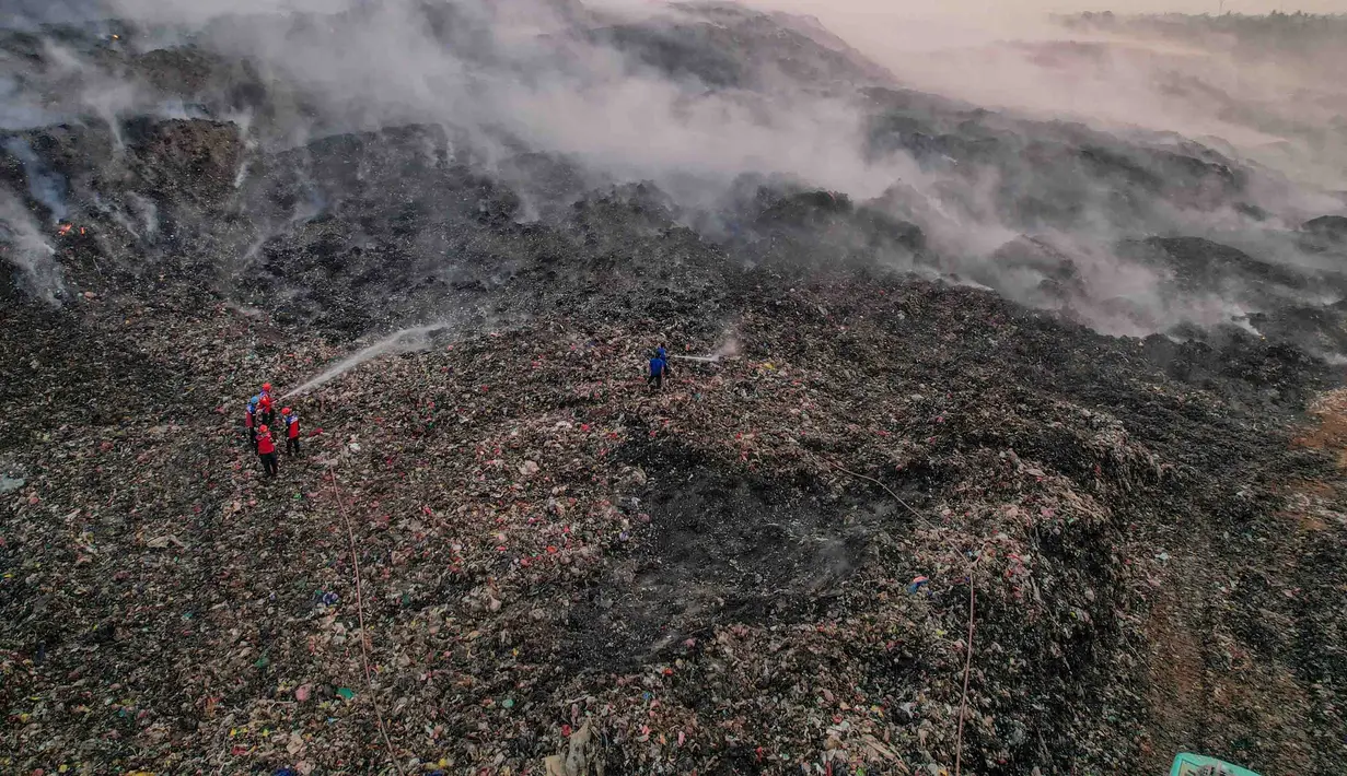 Petugas pemadam kebakaran berusaha memadamkan api di Tempat Pembuangan Akhir (TPA) Jatiwaringin, Kabupaten Tangerang, Banten, Jumat (03/07/2026). (Merdeka.com/ Arie Basuki)