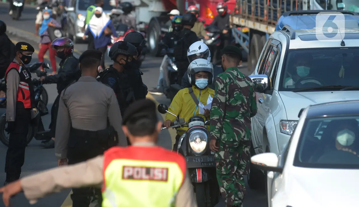 Petugas gabungan memeriksa sejumlah pengendara sepeda motor di pos penyekatan di Jalan Raya Bogor, Jakarta Timur, Selasa (6/7/2021). Petugas Gabungan Polri dan TNI menyiapkan kendaraan taktis untuk membantu penyekatan selama PPKM Darurat Jawa - Bali. (merdeka.com/Imam Buhori)