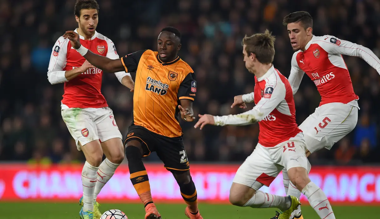 Pemain Hull City, Adama Diomande, berusaha melewati hadangan pemain Arsenal dalam partai ulang putaran kelima Piala FA di Stadion KC, Hull City, Rabu (9/3/2016) dini hari WIB. (AFP/Paul Ellis)