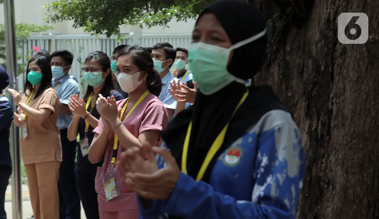 Tenaga kesehatan dan nonkesehatan bertepuk tangan selama 56 detik pada peringatan Hari Kesehatan Nasional ke-56 di RSD Wisma Atlet, Jakarta, Kamis (12/11/2020). Aksi tersebut sebagai bentuk penghargaan kepada tenaga kesehatan yang berjuang menghadapi pandemi COVID-19. (Liputan6.com/Herman Zakharia)