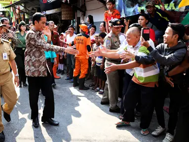 Presiden Joko Widodo didampingi Ibu Negara Iriana disambut warga saat blusukan ke Kedoya dan Petamburan, Jakarta, Selasa (1/9/2015). Selain sembako, Presiden Jokowi juga membagikan buku dan baju kepada anak-anak. (Liputan6.com/Faizal Fanani)