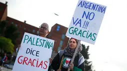 Aktivis pro-Palestina menunjukkan poster ungkapan terima kasih kepada timnas sepak bola Argentina di Barcelona (6/6). Mereka melakukan aksi berterima kasih di depan hotel penginapan pemain timnas Argentina di Barcelona. (AFP Photo/Pau Barrena)