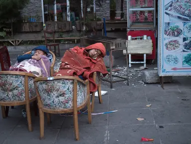 Warga tidur di luar rumah mereka di Zhangzha, provinsi Sichuan, China barat daya, Kamis (10/8). Sejumlah warga memilih menghabiskan malam di luar rumah setelah gempa 6,5 SR mengguncang wilayah tersebut dan menewaskan belasan orang. (Nicolas ASFOURI/AFP)