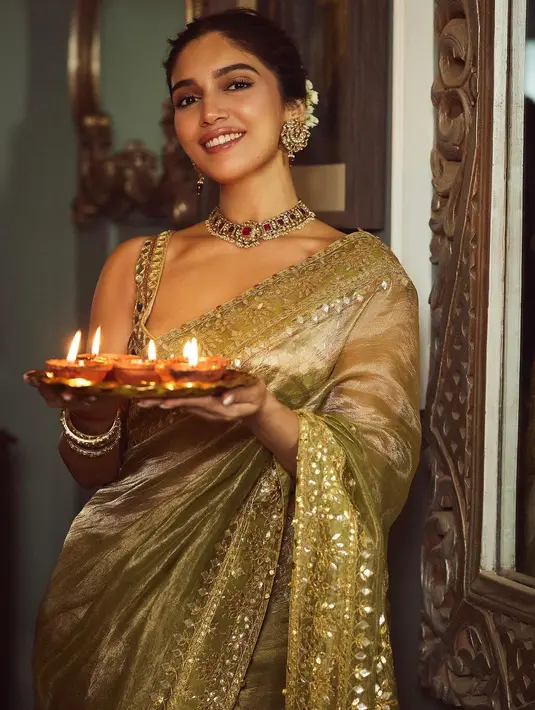 Bhumi Pednekar tampil cantik maksimal dibalut sari nuansa hijau lumut. Penampilannya dipermanis dengan aksesoris berupa kalung, anting, dan hiasan rambut. [@bhumipednekar]