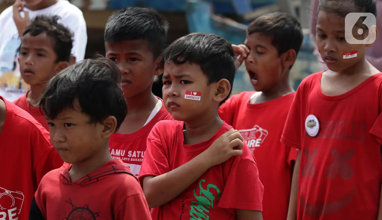Anak-anak yang tergabung dalam Kelas Jurnalis Cilik melaksanakan Upacara Peringatan HUT RI ke-77 di Kawasan Kalibaru Barat, Cilincing, Jakarta, Rabu (17/8/2022). Memperingati Hari Kemerdekaan Indonesia ke-77, anak-anak yang tergabung dalam Kelas Jurnalis Cilik bersama para relawan melaksanakan upacara bendera dan beragam lomba. (Liputan6.com/Helmi Fithriansyah)