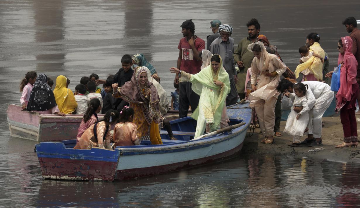 <p>Keluarga-keluarga menaiki perahu di titik piknik untuk merayakan hari raya Idul Fitri, di penghujung bulan puasa Ramadhan, di Lahore, Pakistan, Rabu, 4 Mei 2022. (AP Photo/K.M. Chaudary)</p>