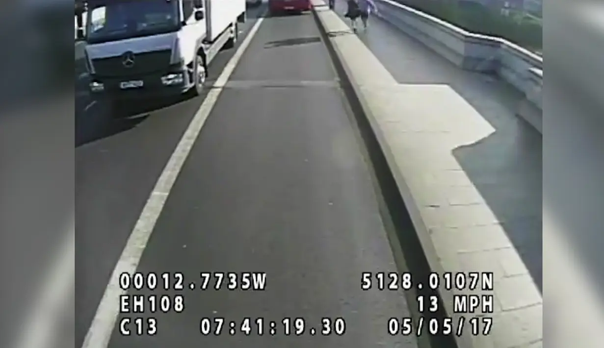 Momen seorang pria mendorong wanita ke jalur bus di Jembatan Putney di London (8/8). Dengan sigap Bus tersebut berhenti tepat sebelum pejalan wanita ini tertabrak. (Polisi Metropolitan via AP)