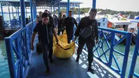 Anggota kepolisian mengangkat kantong jenazah yang berisikan puing-puing dan barang-barang dari jatuhnya pesawat jenis M-28 Skytrcuk milik Polri di Pelabuhan Telaga Punggur, Batam, Kepulauan Riau, Minggu (4/12). (Antara Foto/M N Kanwa/via REUTERS)