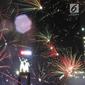 Kembang api menghiasi malam pergantian tahun baru 2019 di kawasan Bundaran HI, Jakarta, Selasa (1/1). Hujan yang mengguyur Jakarta tidak menyurutkan warga menikmati kembang api tahun baru. (Liputan6.com/Angga Yuniar)