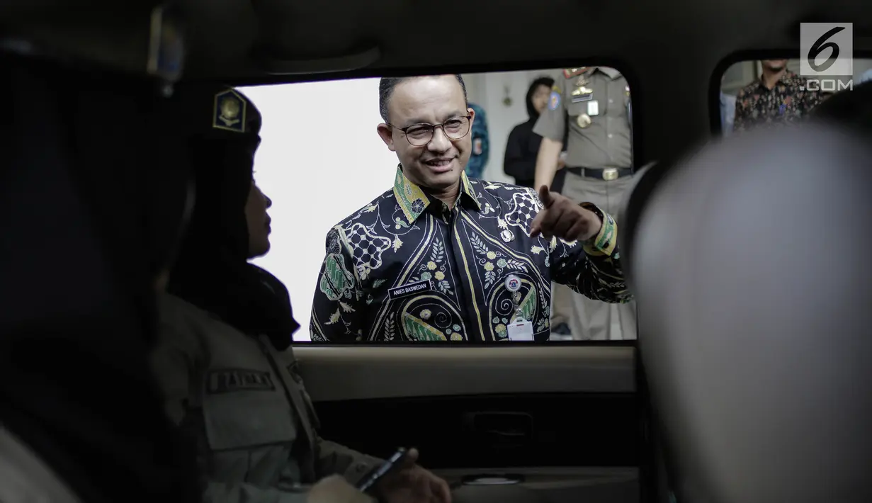 Gubernur DKI Jakarta Anies Baswedan berbincang dengan personel Satpol PP saat pelapasan di halaman Pendopo Balai Kota, Jakarta, Kamis (29/3). (Liputan6.com/Faizal Fanani)