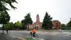 Seorang pesepeda melintas di Trafford Town Hall, Greater Manchester, Inggris (2/9/2020). Menurut BBC, sejumlah wilayah di Greater Manchester tidak akan melonggarkan pembatasan lockdown sesuai rencana awal karena pemerintah membatalkannya. (Xinhua/Jon Super)