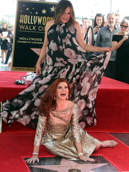 Akrtis asal Amerika Serikat, Debra Messing dan rekannya, Mariska Hargitay bercanda di plakat bintang atas namanya pada upacara pengargaan di Hollywood Walk of Fame, Los Angeles, Jumat (6/10). (Photo by Willy Sanjuan/Invision/AP)