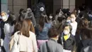 Orang-orang yang mengenakan masker pelindung untuk membantu mengekang penyebaran virus corona COVID-19 berjalan di sepanjang penyeberangan pejalan kaki di Tokyo, Jepang, Kamis (15/4/2021). Tokyo mengonfirmasi lebih dari 700 kasus baru COVID-19 pada 15 April 2021. (AP Photo/Eugene Hoshiko)