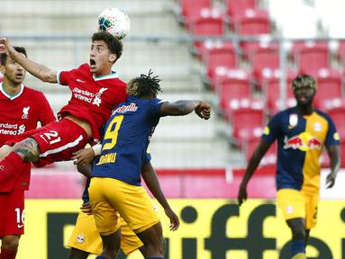 Pemain Liverpool, Kostas Tsimikas, berebut bola dengan pemain RB Salzburg, Chukwubuike Adamu, pada laga persahabatan di Stadion Red Bull Arena, Salzburg, Selasa (25/8/2020). Kedua tim bermain imbang dengan skor 2-2. (AP Photo/Matthias Schrader)