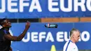 Paul Pogba melempar botol minum saat pelatih, Didier Deschamps sedang mengawasi latihan sebelum melawan Jerman pada laga semi-final di Centre d'Entrainement Robert Louis-Dreyfus, Marseille, (6/7/2016).(AFP/Franck Fife)
