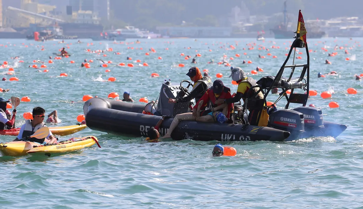 Petugas menyelamatkan perenang yang kelelahan ketika lomba renang lintas pelabuhan berjarak 1.500 meter di Hong Kong, Minggu (16/10). Sejumlah peserta lomba renang tahunan Lintas Pelabuhan Hong Kong mengalami kelelahan dan tenggelam. (REUTERS/APPLE DAILY)
