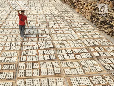 Pekerja mengeringkan kerupuk kaleng di industri UMKM Nineung di Pamulang, Tangsel, Banten, Jumat (21/6/2019). Kenaikan harga tepung tapioka yang mencapai lebih dari seratus persen semenjak beberapa bulan terakhir menyebabkan produsen kerupuk mengurangi kualitas kerupuk. (merdeka.com/Arie Basuki)