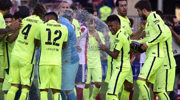  Pemain Barcelona merayakan gelar juara La Liga yang baru saja di raih. Barcelona memastikan meraih gelar La Liga Spanyol musim 2014/2015 setelah menang atas tuan rumah Atletico Madrid 1-0 di Stadion Vicente Calderon, Minggu (17/5). (AFP PHOTO / GERARD JU