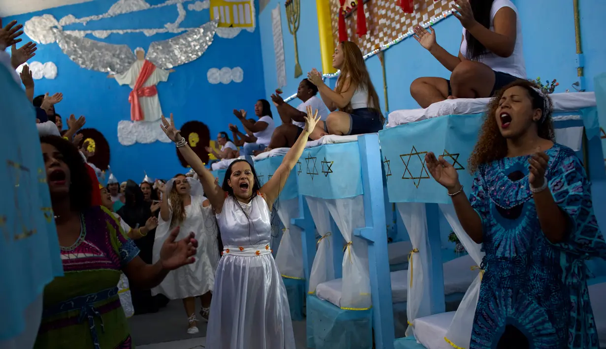 Narapidana perempuan mengenakan kostum dalam acara tahunan menjelang  natal di Penjara Nelson Hungria, Rio de Janeiro, Kamis (13/12). Para tahanan juga menyanyikan lagu religi dan memainkan drama perjalanan hidup Yesus. (AP/Silvia Izquierdo)