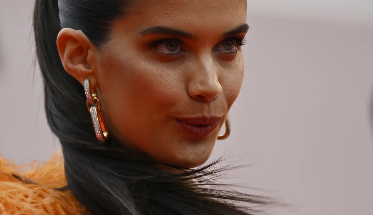 Dia menata rambut cokelatnya yang disisir ke belakang menjadi sanggul yang chic, melengkapi penampilannya dengan anting-anting emas. (AFP/Loic Venance)