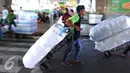 Pekerja mengangkut pakaian yang telah dikemas di kawasan Tanah Abang, Jakarta, Jumat (27/5). Jelang Ramadan penjualan pakaian yang akan di kirim ke berbagai daerah mengalami peningkatan. (Liputan6.com/Angga Yuniar)