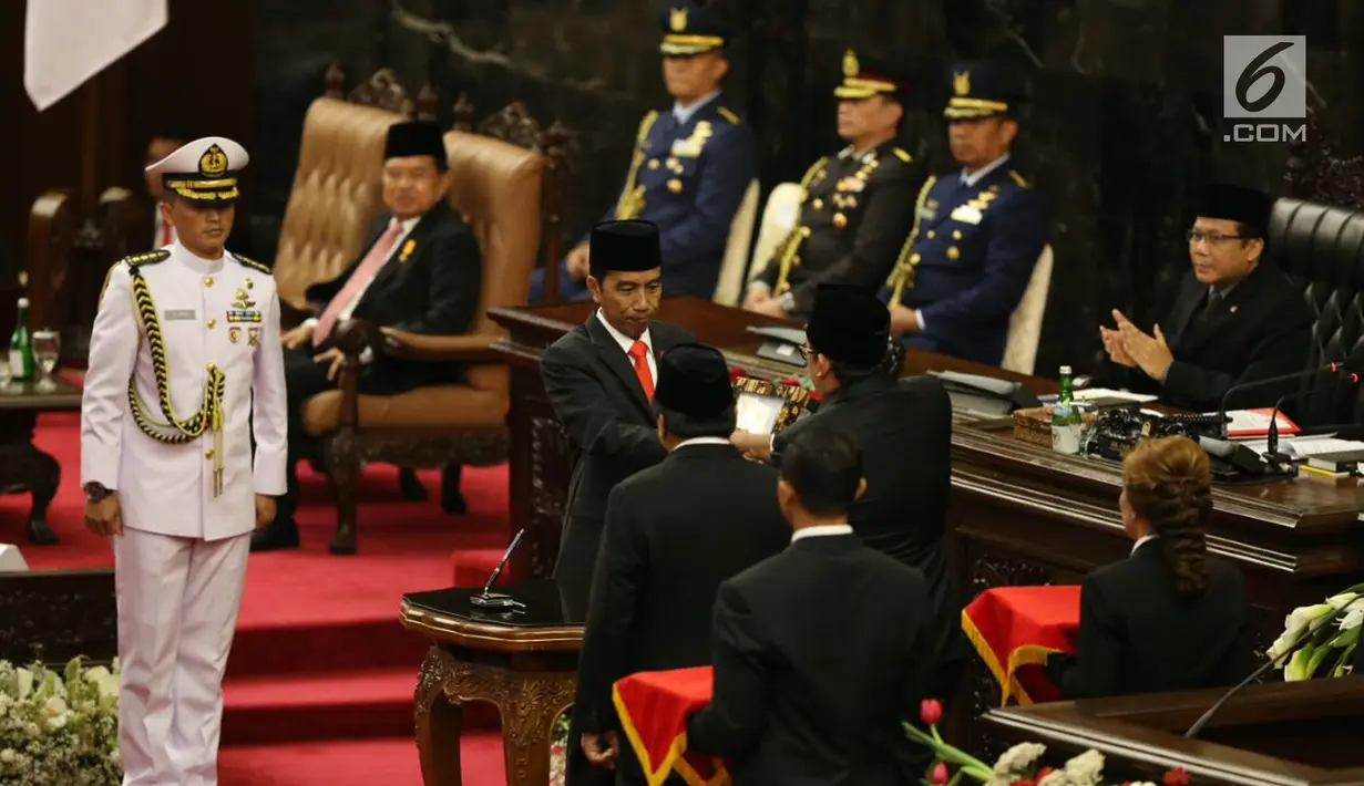 Presiden Joko Widodo berjabat tangan dengan Wakil Ketua DPR Fadli Zon usai menandatangani Nota Keuangan dan RAPBN 2018 di Kompleks Parlemen, Senayan, Jakarta, Rabu (16/8). (Liputan6.com/Johan Tallo)
